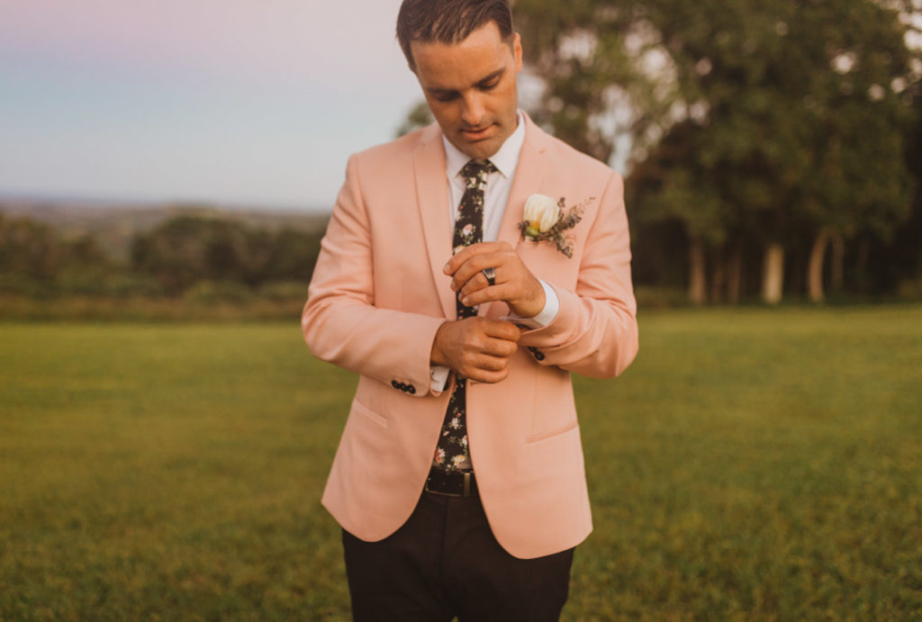 groom in pink suit and floral tie