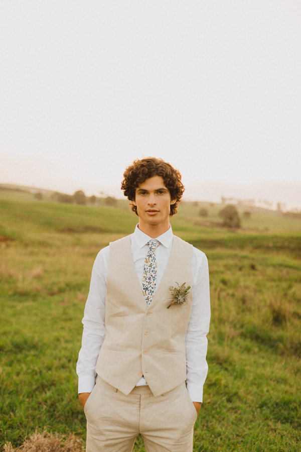 groom in tan linen suit and floral tie