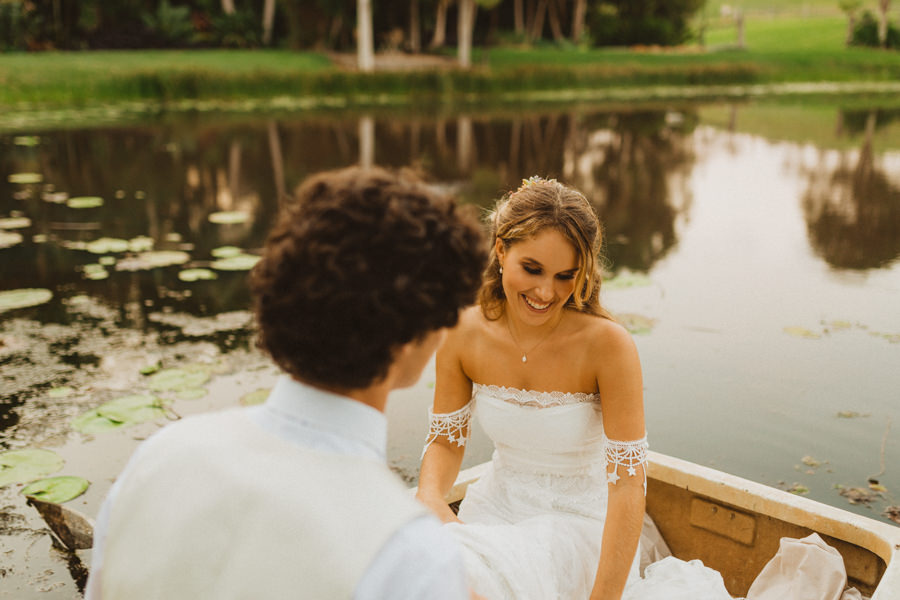 bride and groom in rowboat over lake