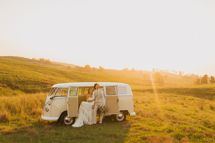 Couple elope at sunset with a Volkswagen bus. Discover Ways to Include Your Friends & Family at Your Elopement.
