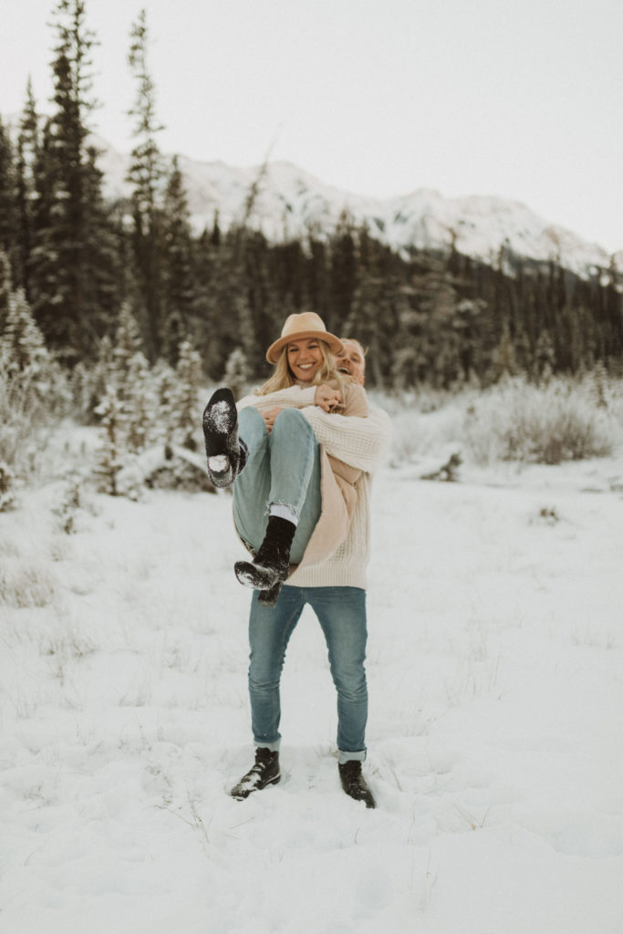 fun engagement pose in the mountians