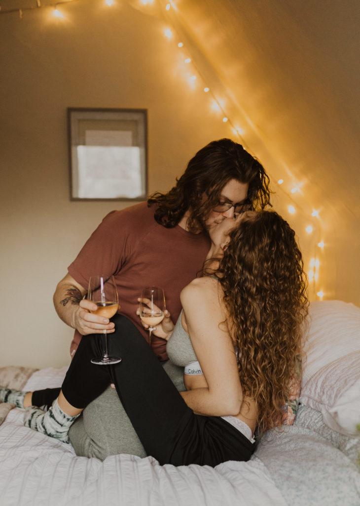 cozy in-home couple's session drinking wine in bed
