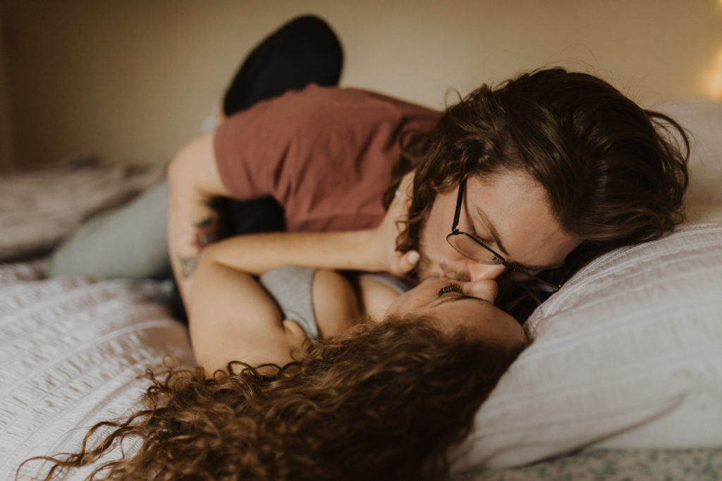 in-home session, couple kissing on bed