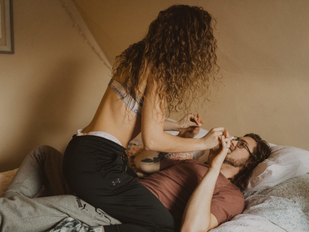 cozy in-home session, couple playing on bed