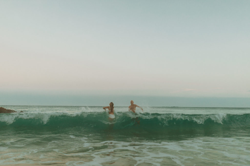 couple playing in ocean waves photography