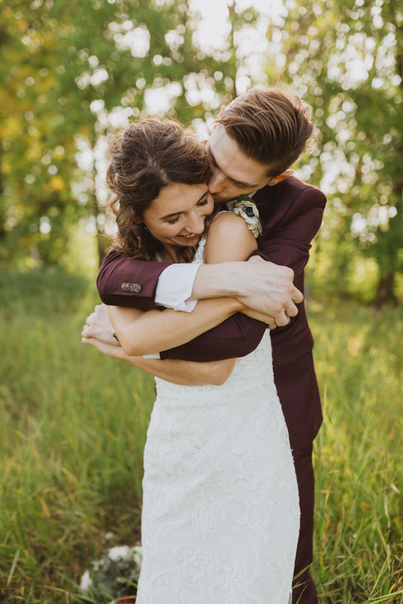groom hugging bride from behind during fall wedding in Winnipeg