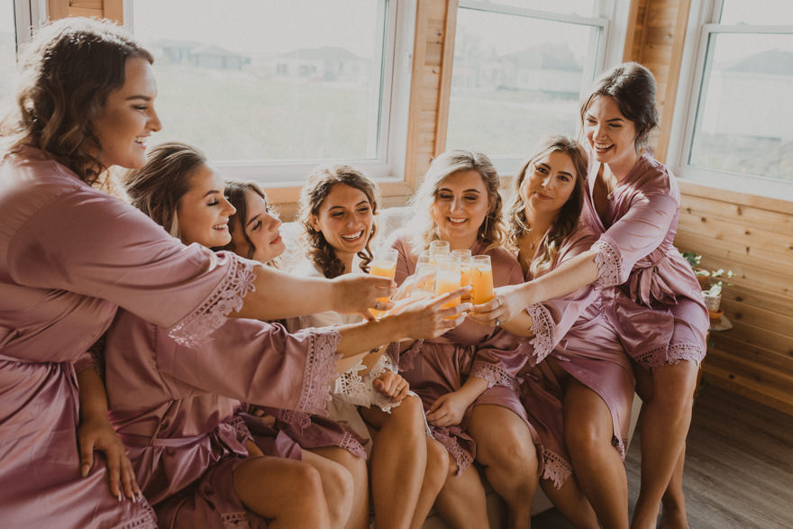 bridesmaids drinking mimosas while getting ready for wedding 