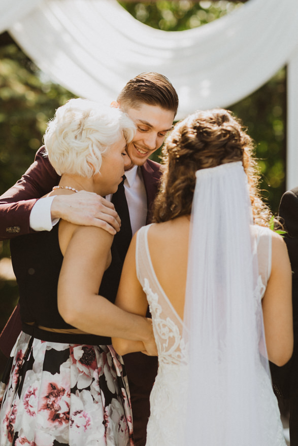 groom hugging bride's parents after they give her away