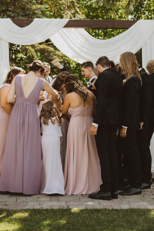 wedding party praying for bride and groom after getting married, christian wedding, prayer of blessing