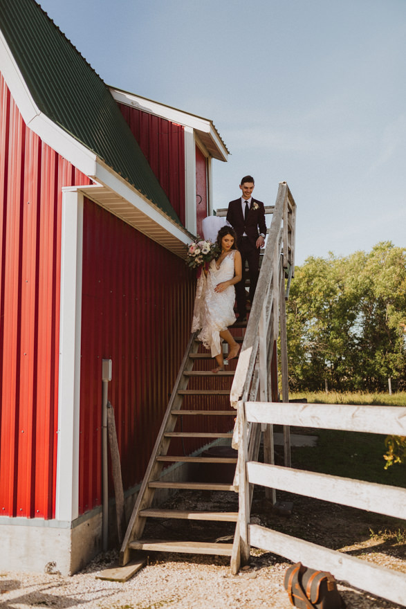 Bride and groom walking out of barn