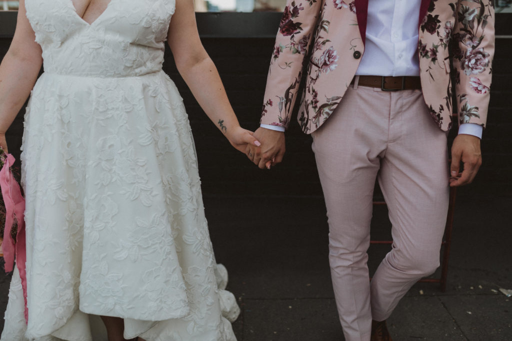 bride and groom with style. lace, high-low dress from BHLDN and pink floral tux from ASOS
