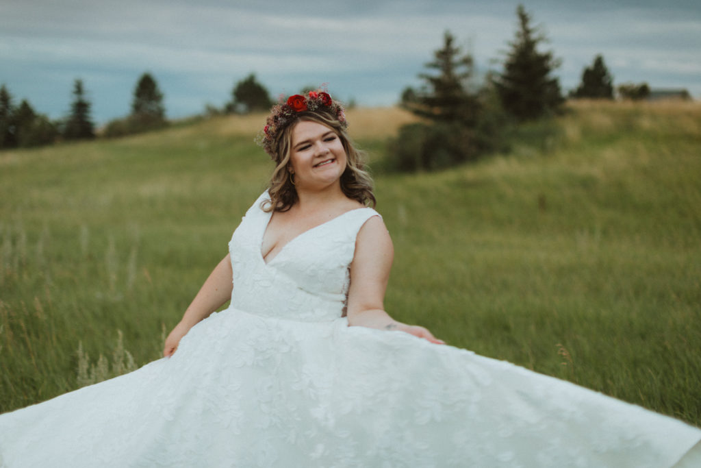 bride in BHLDN dress from Blush and Raven YYC holding colourful bouquet and wearing a flower crown of dried flowers