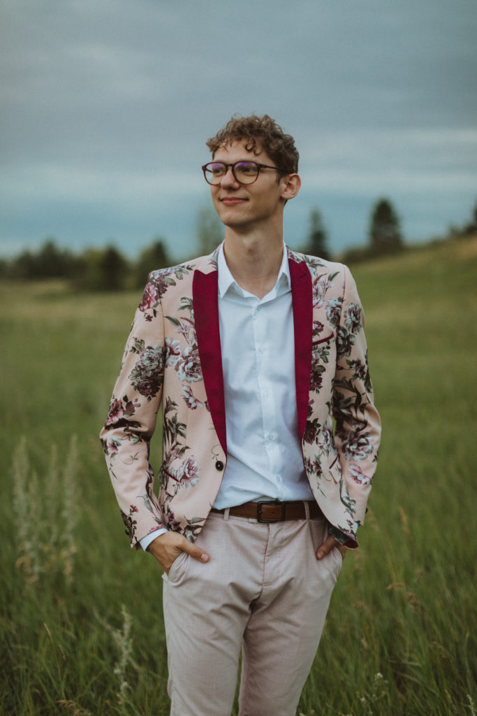 groom in pink floral suit from asos and curly hair and glasses