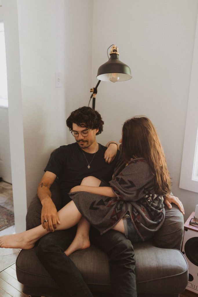 couple commemorates their first home together with an in-home photography session. Photo of them cozying up on a loveseat