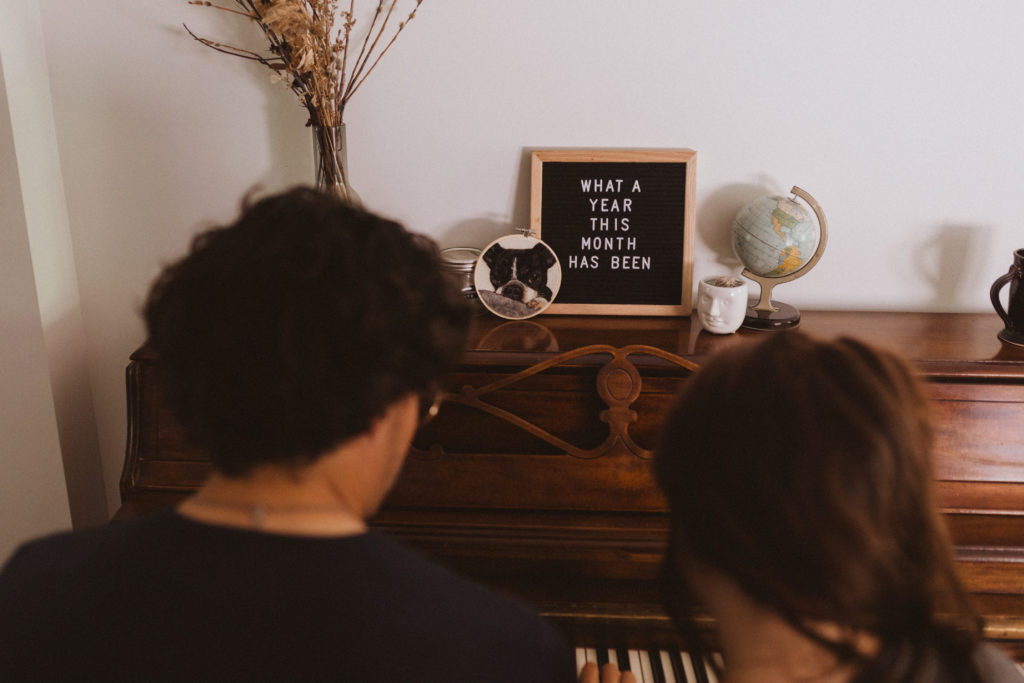 couple playing piano in their home during their in-home photography session