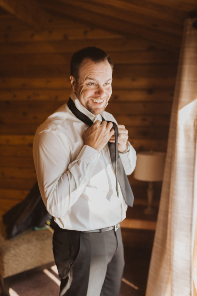 groom getting ready the morning of his elopement day. Don't forget to include getting ready photos into your elopement timeline.