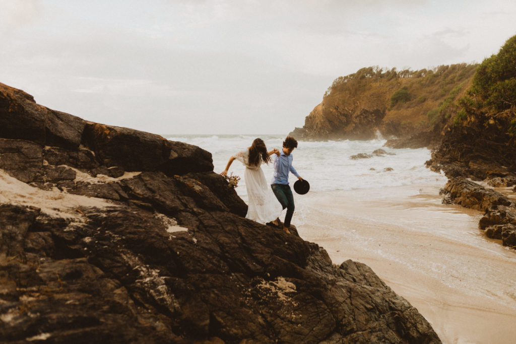 What makes an elopement day different than a traditional wedding day? It mostly all lies in the timeline. The bride and groom are climbing up rocks next to the ocean because they left room for exploring and spontaneity on their elopement day.
