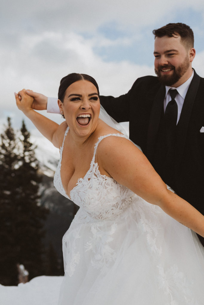 Elopement portraits from Banff Gondola elopement on Sulphur Mountain. Bride and groom flying like an airplane for a fun couples prompt.