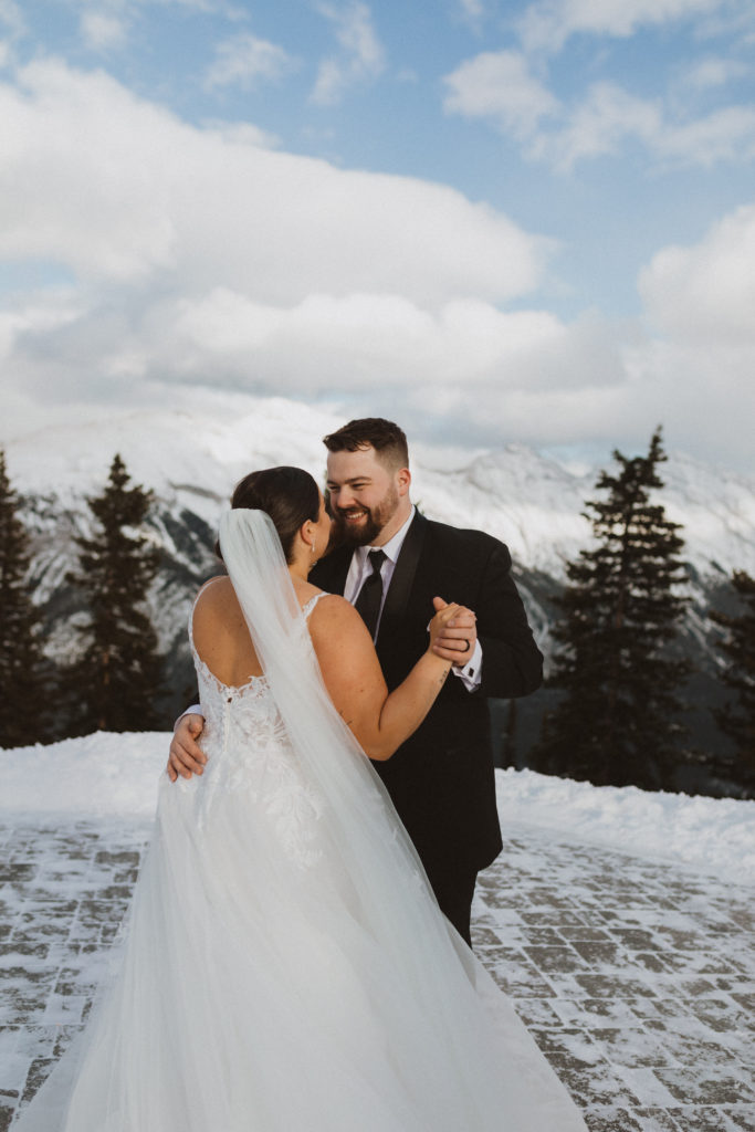 Bride and groom have their first dance up the Banff Gondola for their elopement. On top of sulphur mountain. Elopement photography by Liv Hettinga, a Banff National park photographer.