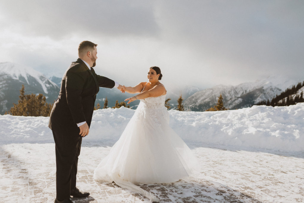 Bride and groom have their first dance up the Banff Gondola listening to their favourite song and spinning each other around. Mountain winter elopement in Banff National Park captured by Liv Hettinga Photography.