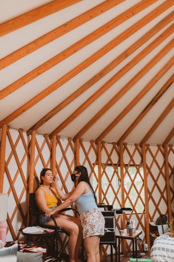 Bridesmaid getting makeup done in a yurt by Jasmeet Dhillon of Beauty Himmel. Getting ready for elopement day.