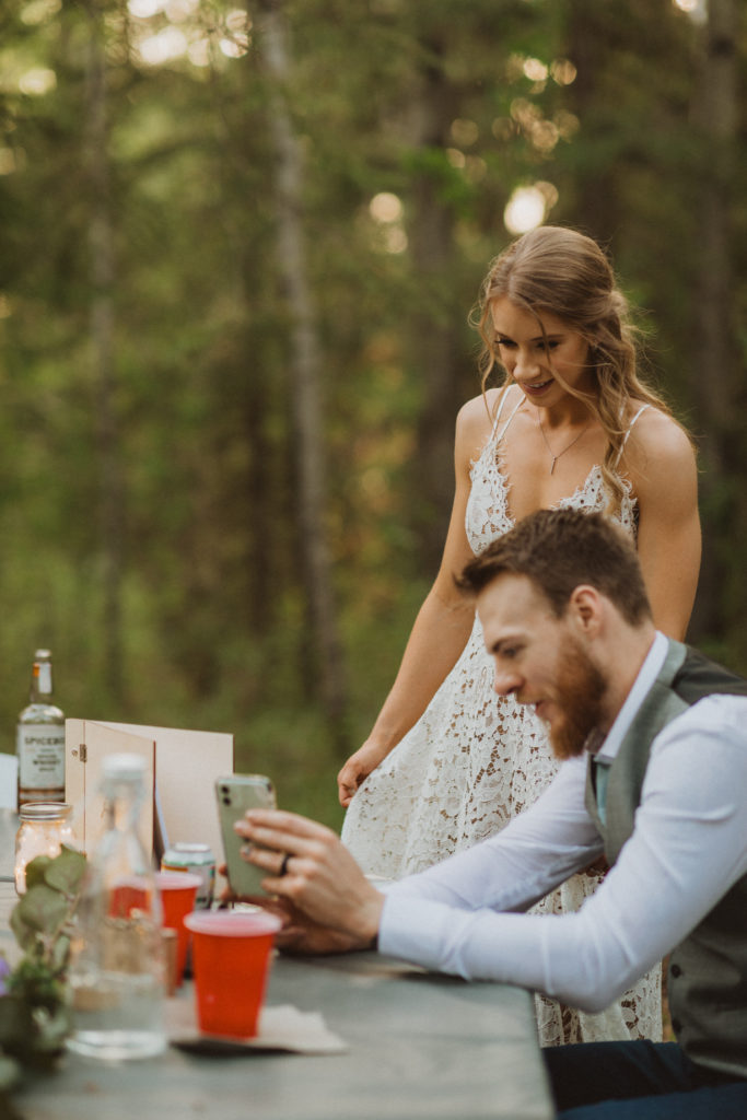 bride and groom facetiming parents during reception dinner. Involve your family in your elopement day even if they aren't present.