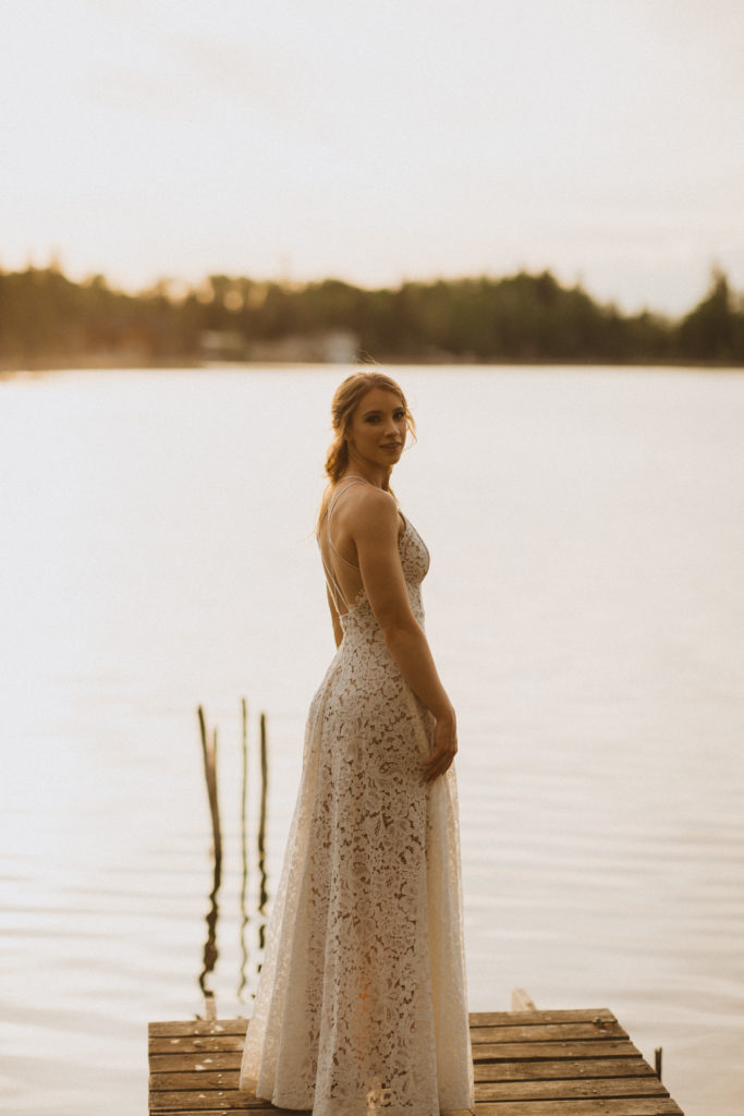 Bride portraits standing on the dock in front of the lake.