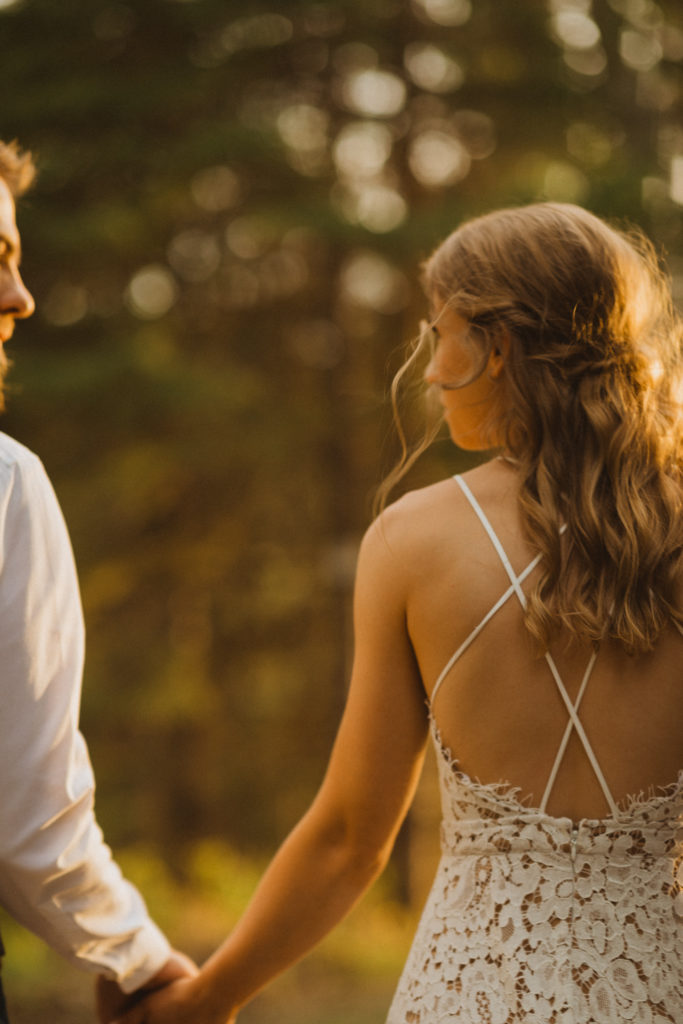 Flora Bora yurt elopement in the forest. Bride and Groom wedding portraits. Posing ideas. Couple photos by Liv Hettinga Photography a Saskatchewan elopement photographer. Sunset portraits holding hands and walking through the trees.