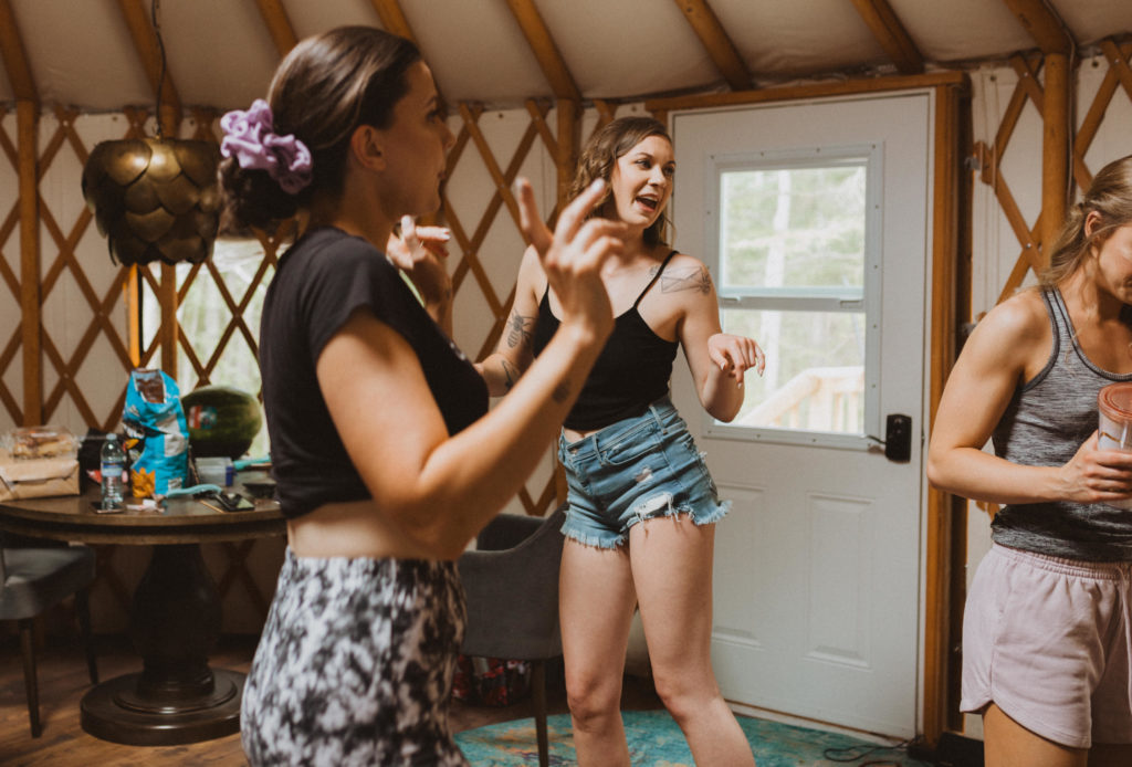 Girls dancing while getting ready for elopement inside a yurt.