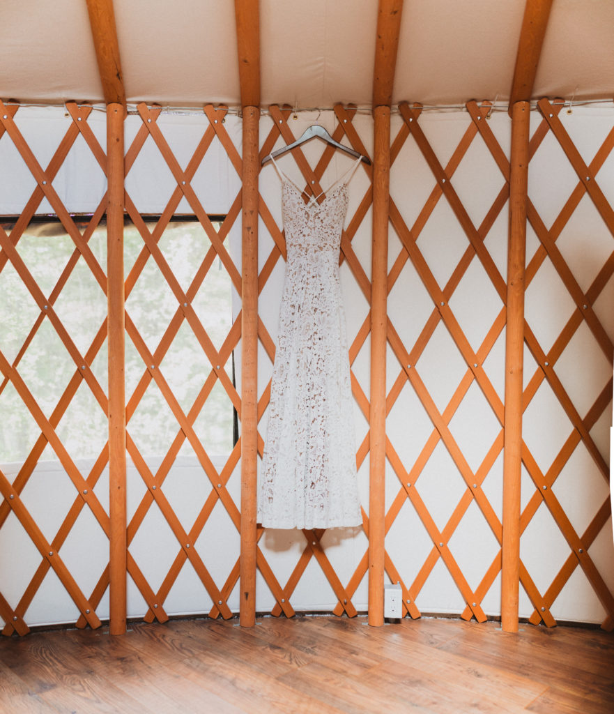 Lace wedding dress with a nude lining from lulus hanging in a yurt. Detail shots from elopement day while getting ready.