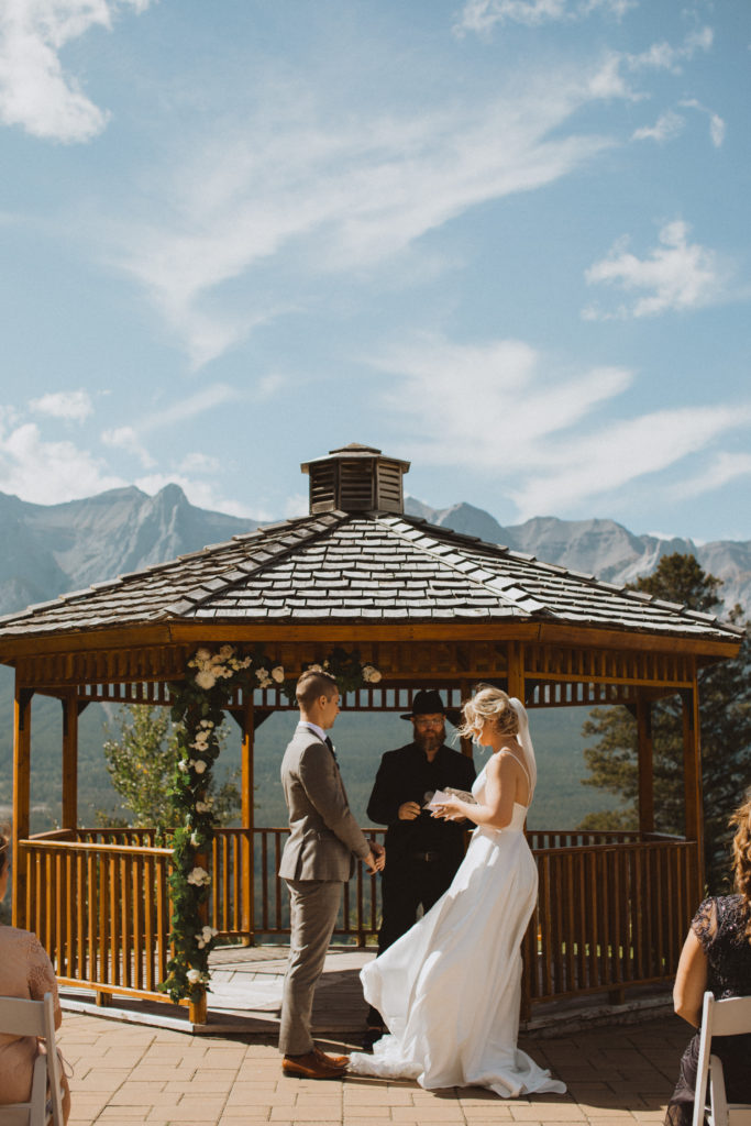 Saying their vows in front of a beautiful moutnain view at their Canmore elopement