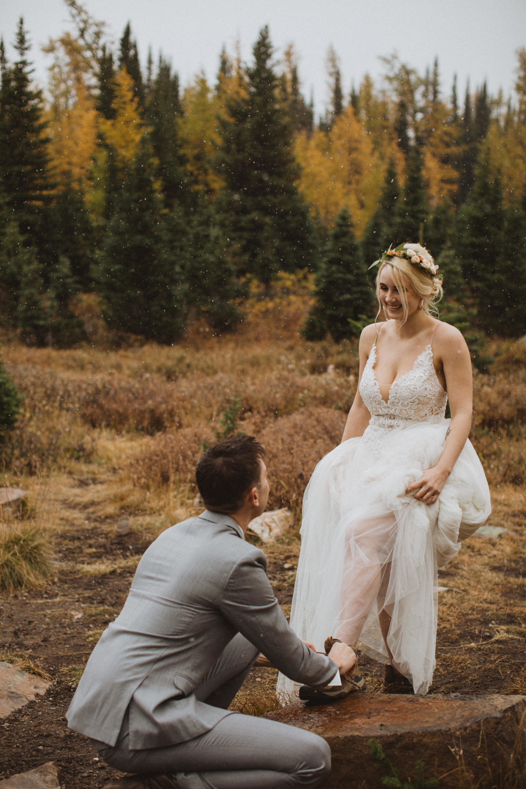 groom tying bride's hiking boots as they hit the trails on their elopement day hiking