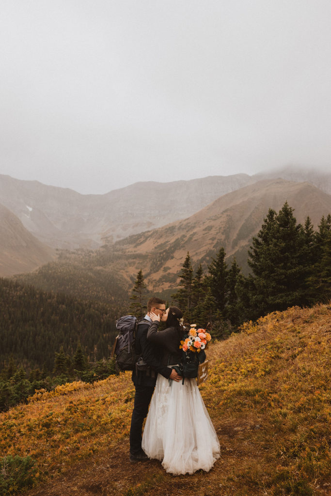 bride and groom practicing leave no trace during their hiking elopement in Kananaskis, Alberta
