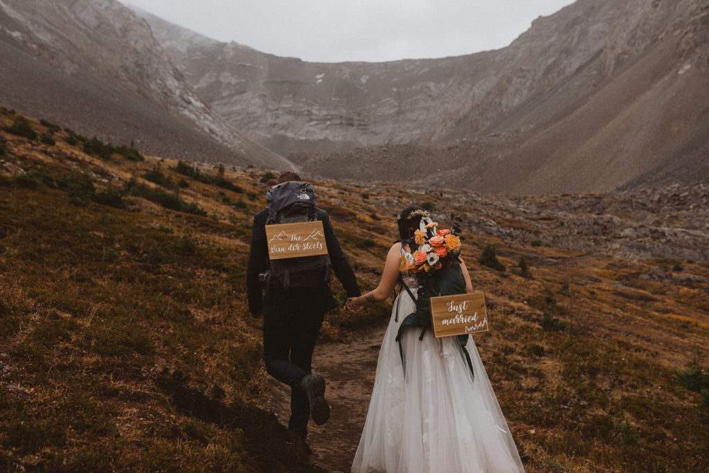 Newlyweds hike up a mountain to their adventure elopement in Kananaskis, Alberta