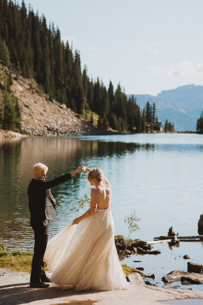 couple has their first dance in front of the lake 