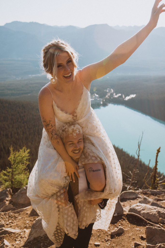 bride sitting on groom's shoulders after their hiking elopement