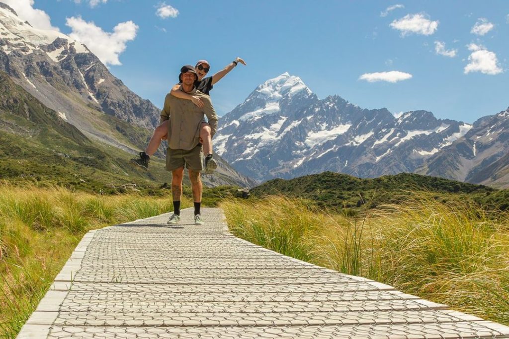 couple on path hiking hooker valley in mt cook national park in new zealand