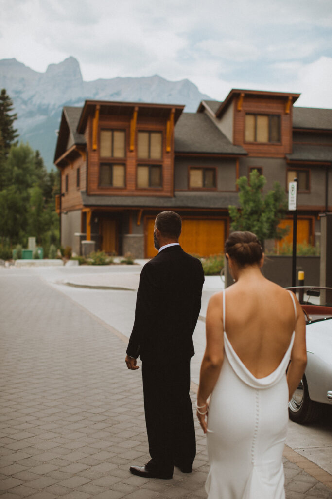 bride and groom first look outside airbnb condo in Canmore, Alberta 
