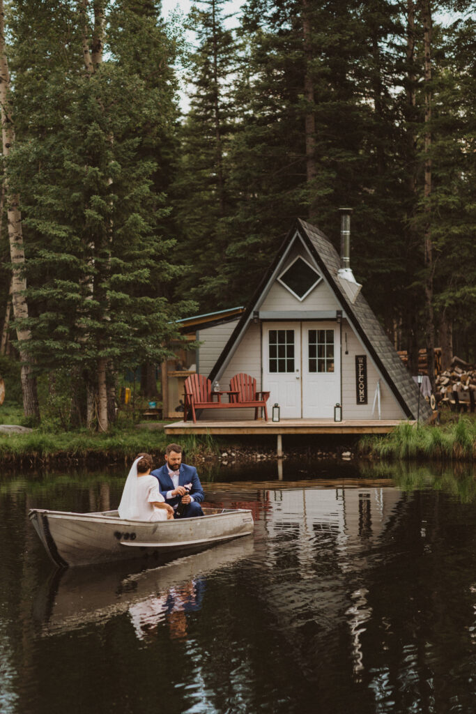 airbnb elopement in Hinton, Alberta in an A-frame cabin with couple paddling on the pond outside