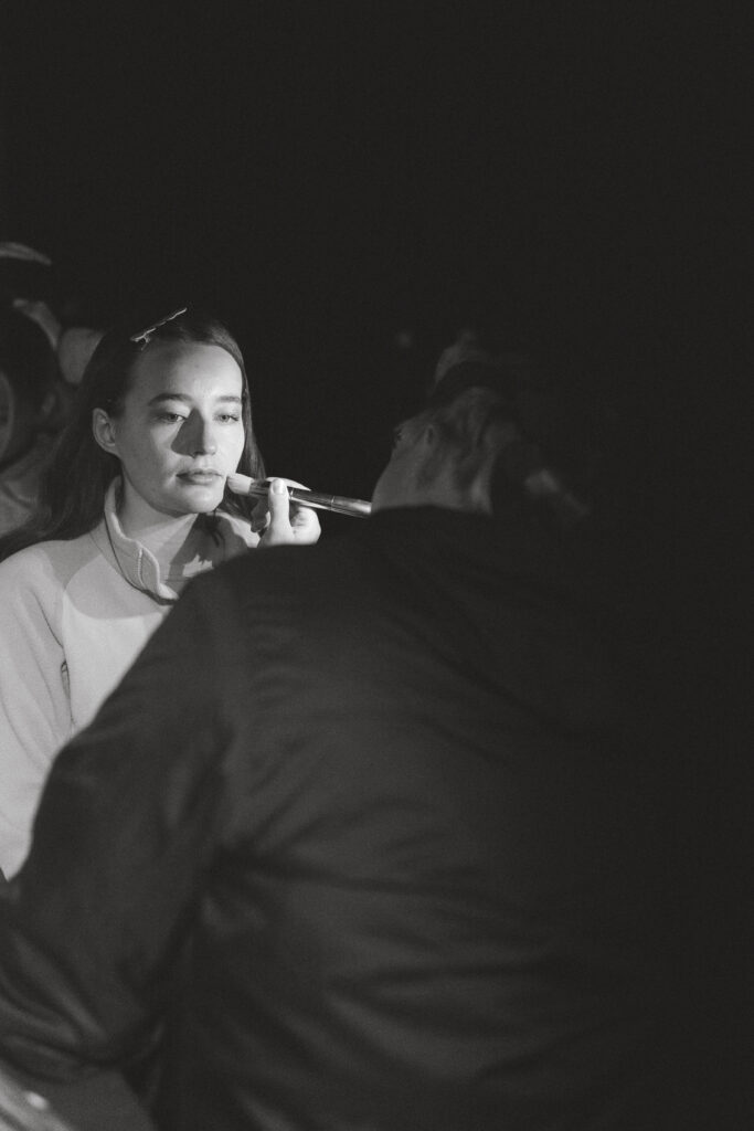 black and white photo getting ready in the dark for sunrise hike during backcountry banff elopement, sister doing makeup